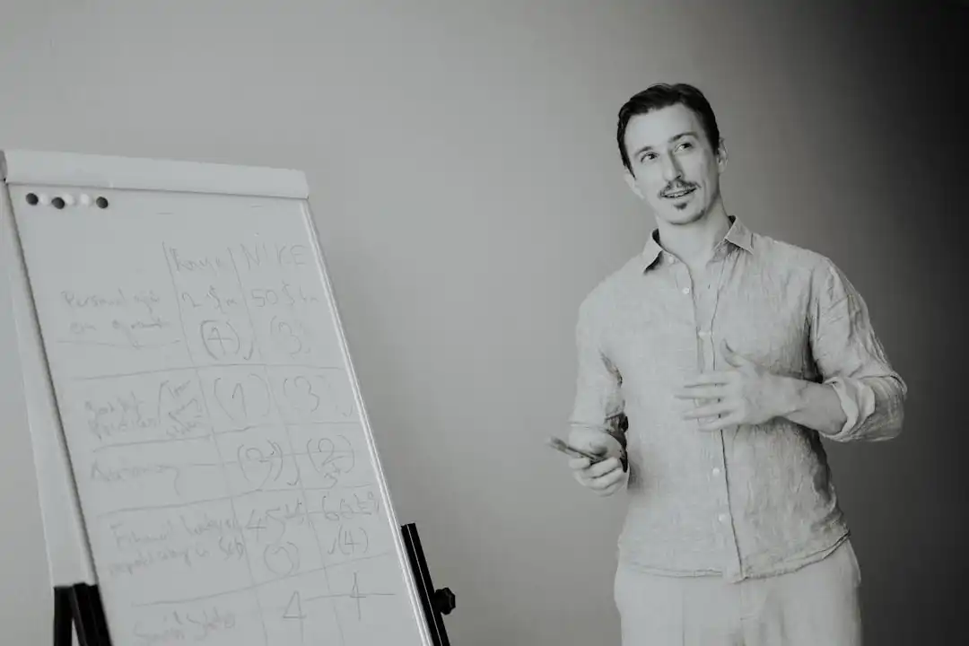Man presenting at a whiteboard in a meeting.