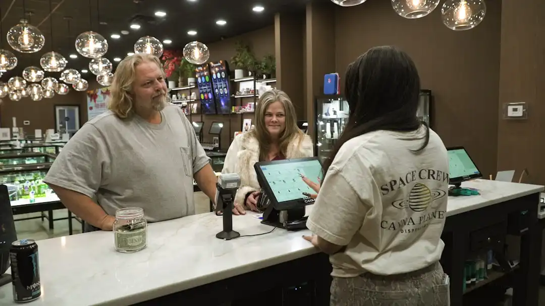 Customers interact with staff at a dispensary counter.